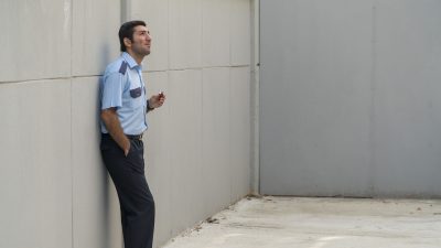 Filmbild Passed by Censor: Ein Mann in Uniform blickt in einem Gefängnishof nach oben.